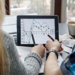 Zbliżenie kolegów dyskutujących nad wykresem w cyfrowym tabletu w biurze