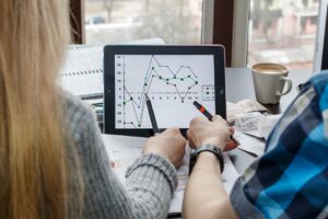 Zbliżenie kolegów dyskutujących nad wykresem w cyfrowym tabletu w biurze