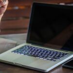 Środkowa część mężczyzny pracującego na laptopie w biurze