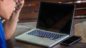 Środkowa część mężczyzny pracującego na laptopie w biurze