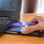 Zbliżenie osoby używającej laptopa na stole