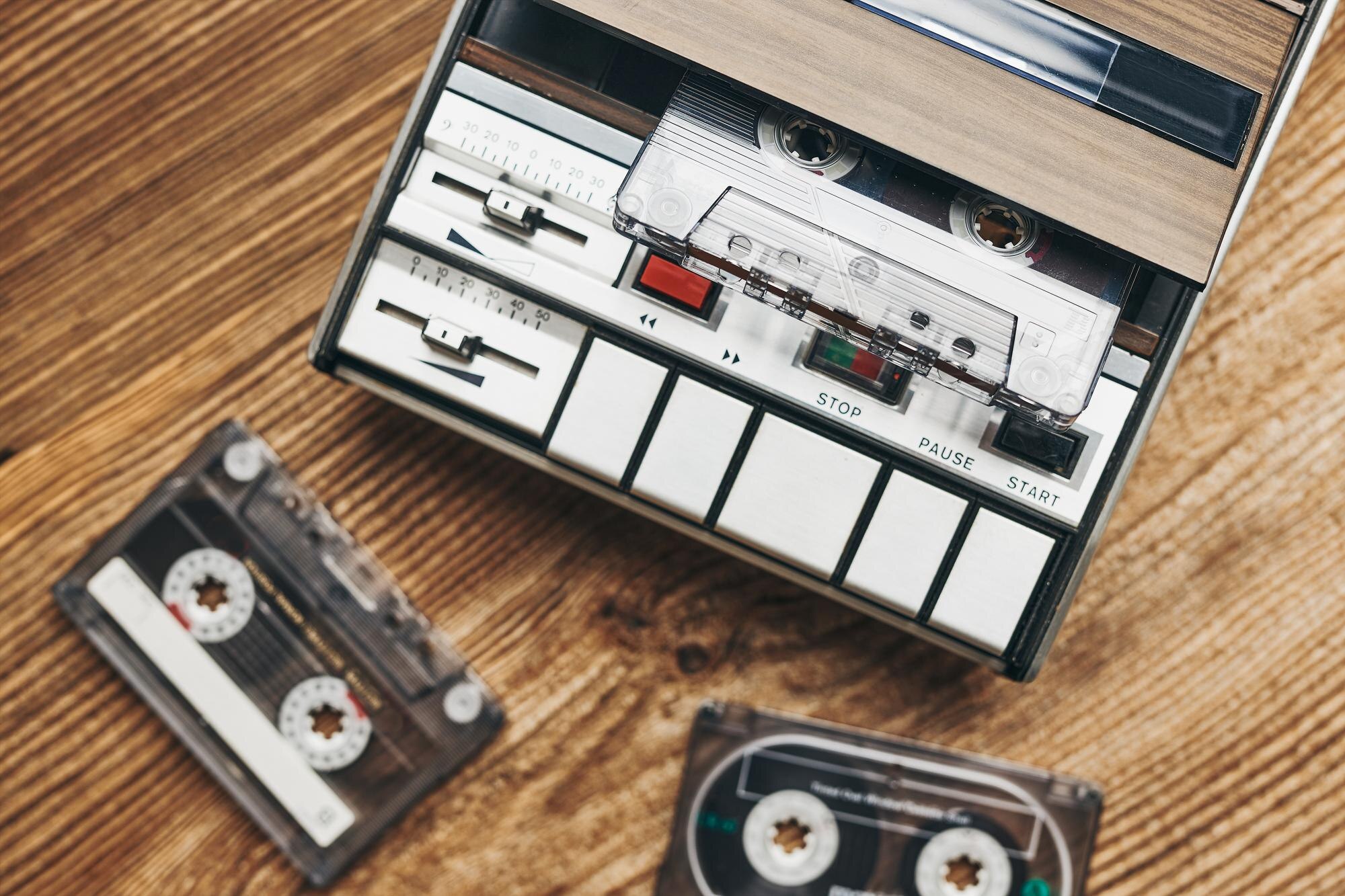 Kompaktne kasety kasetowe i magnetofon na drewnianym stole muzyka retro w stylu lat 80. impreza muzyczna