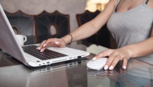 Kobieta używa białego laptopa w domu.