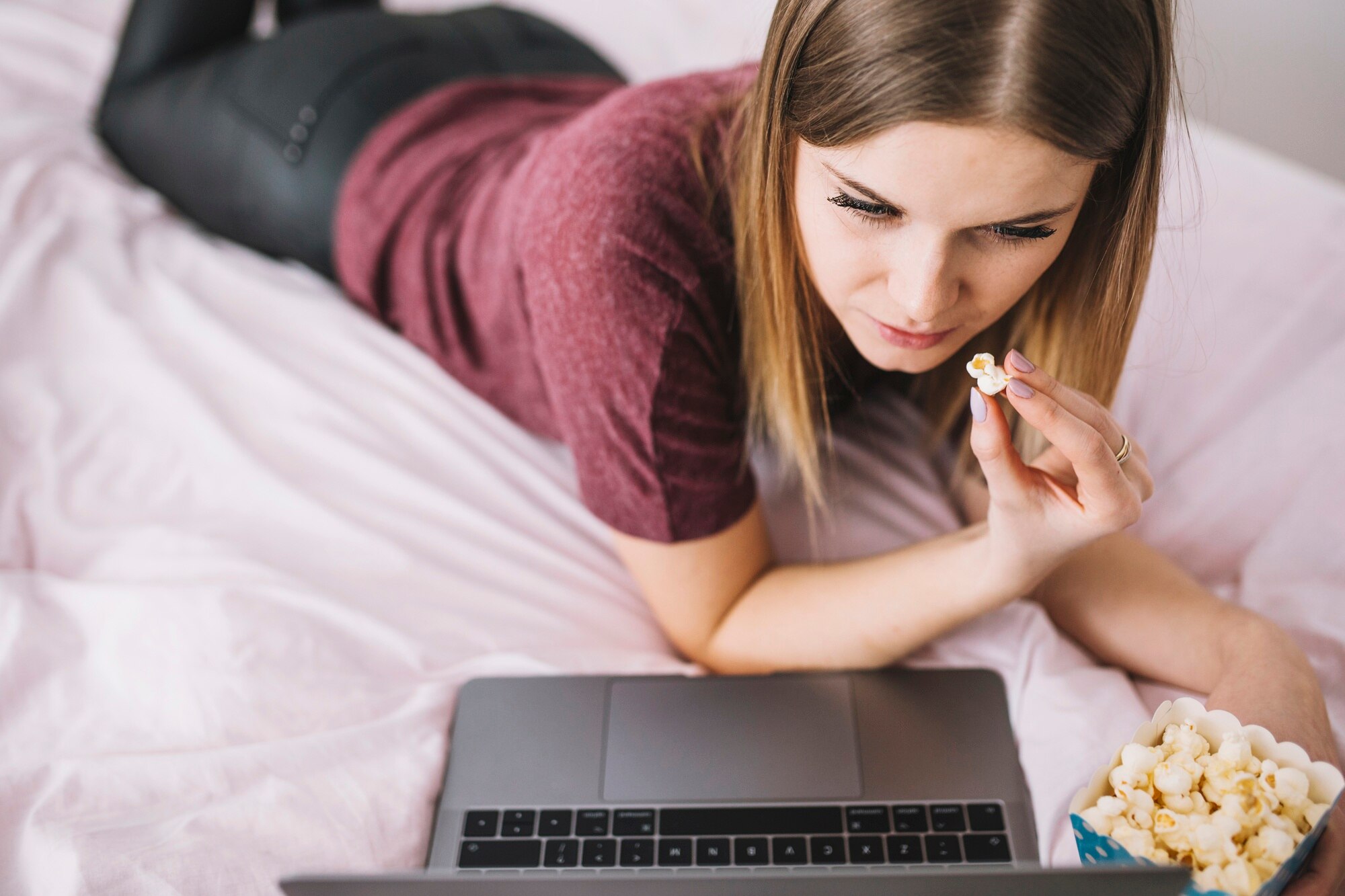 Kobieta z popcornem ogląda film na laptopie