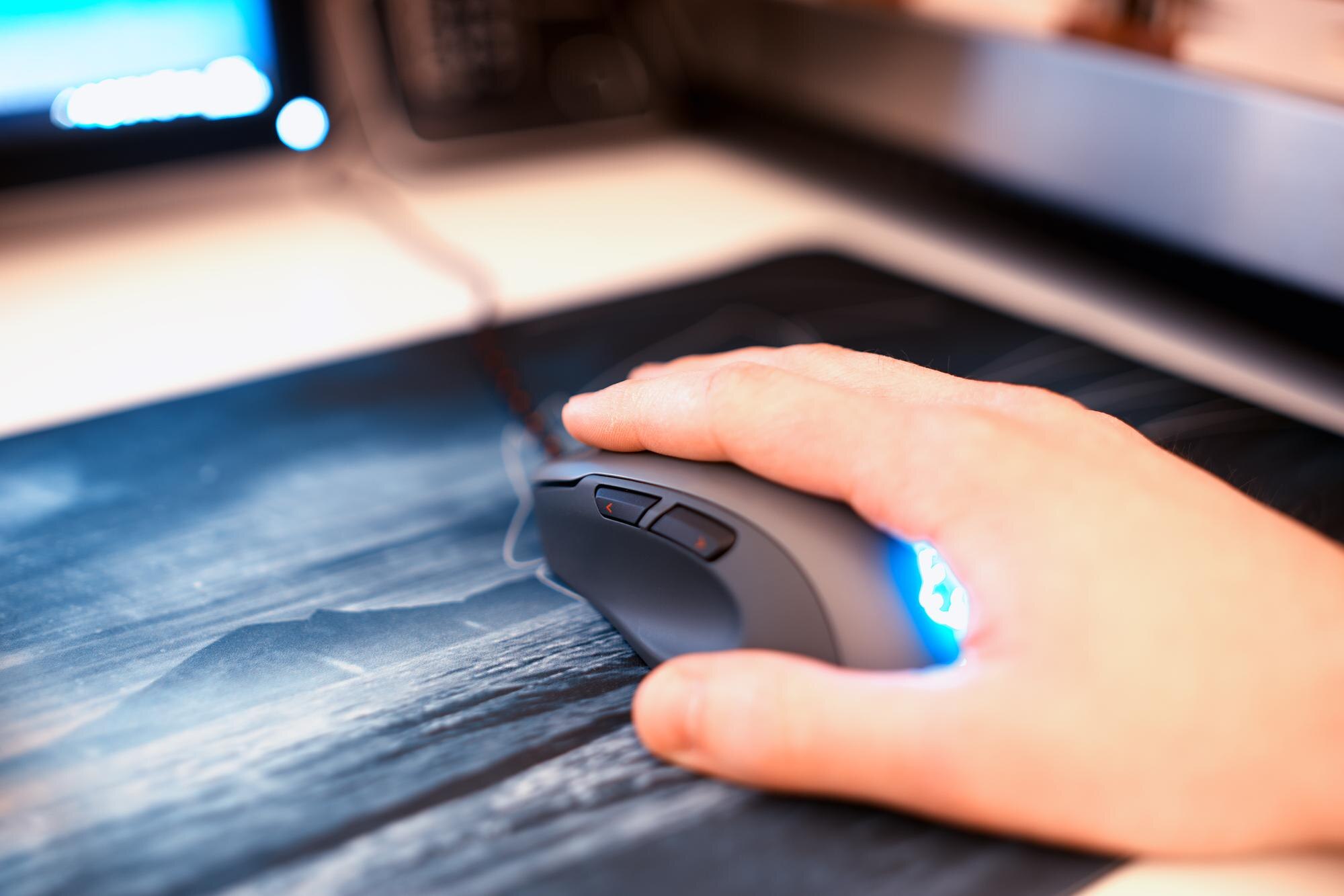 Mysz komputerowa z ludzką ręką na podkładce pod mysz bokeh w tle hd