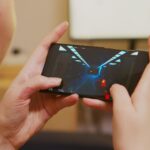 Widok kobiety gry strzelanki na smartfonie z tyłu.