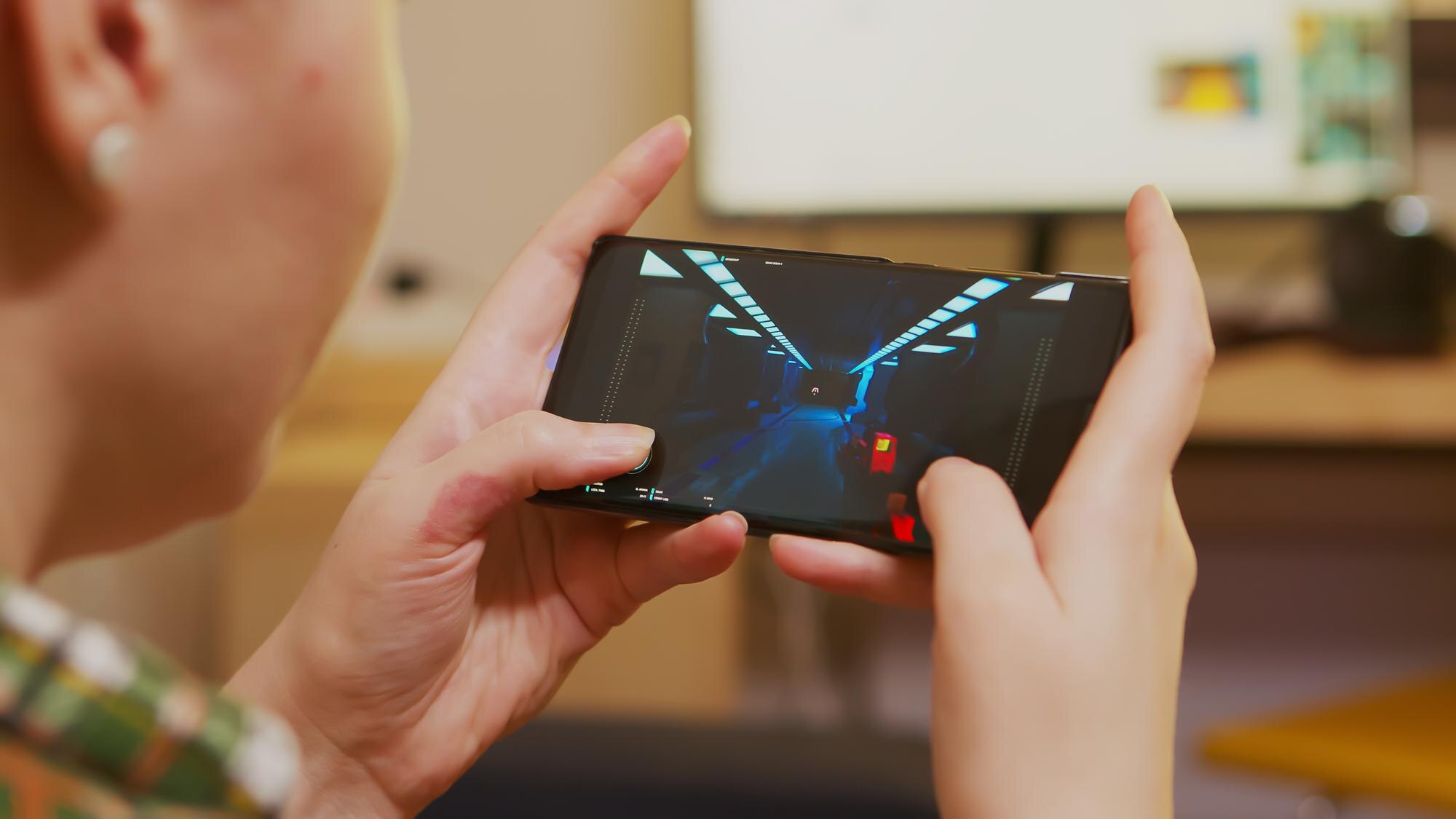 Widok kobiety gry strzelanki na smartfonie z tyłu.