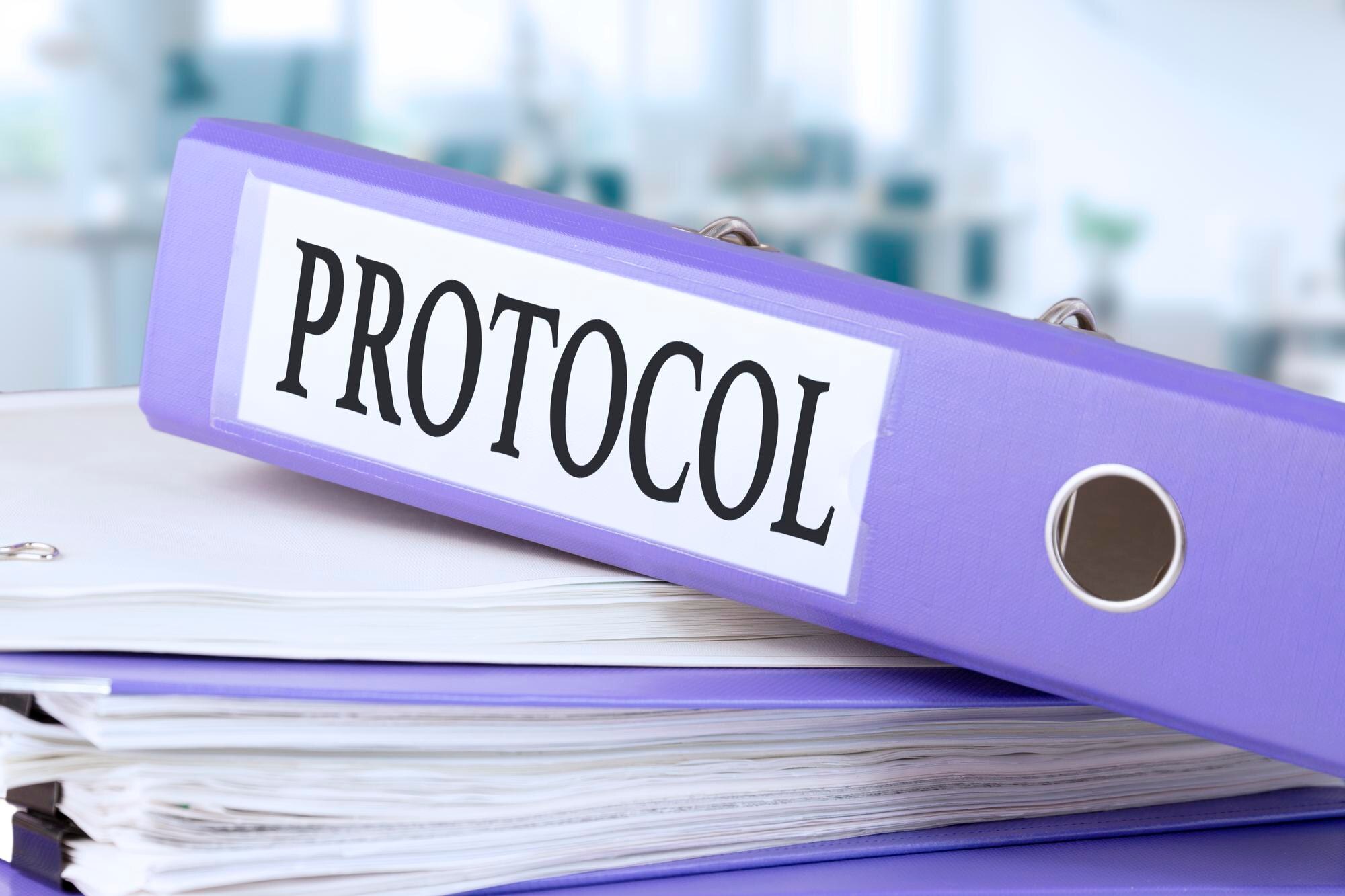 Protokół, tekst zapisany w teczce z dokumentami w modnym fioletowym kolorze, leżące na stosie papierów, dokumenty na biurowym biurku, na tle biurowego rozmytego miękkiego tła. Wysoka jakość ph