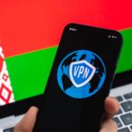 VPN na Białorusi Koncepcja bezpiecznego i bezpiecznego internetu Prywatność Ręka z telefonem komórkowym i aplikacją VPN Flaga i laptop na zdjęciu w tle