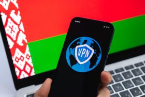 VPN na Białorusi Koncepcja bezpiecznego i bezpiecznego internetu Prywatność Ręka z telefonem komórkowym i aplikacją VPN Flaga i laptop na zdjęciu w tle