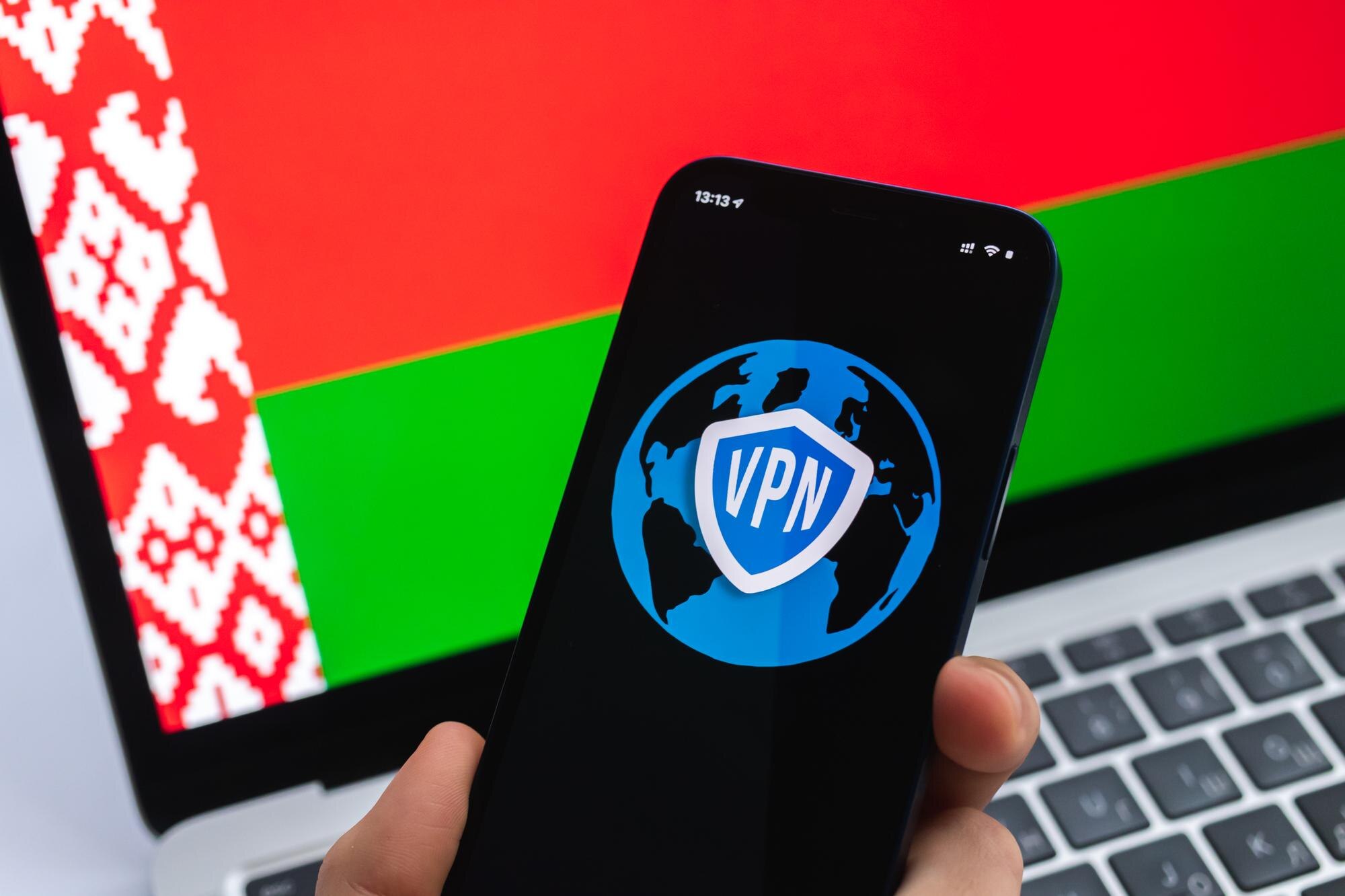 VPN na Białorusi Koncepcja bezpiecznego i bezpiecznego internetu Prywatność Ręka z telefonem komórkowym i aplikacją VPN Flaga i laptop na zdjęciu w tle