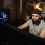 Mężczyzna z brodą w czapce profesjonalny programista tworzenie bazy danych informatyk pracujący