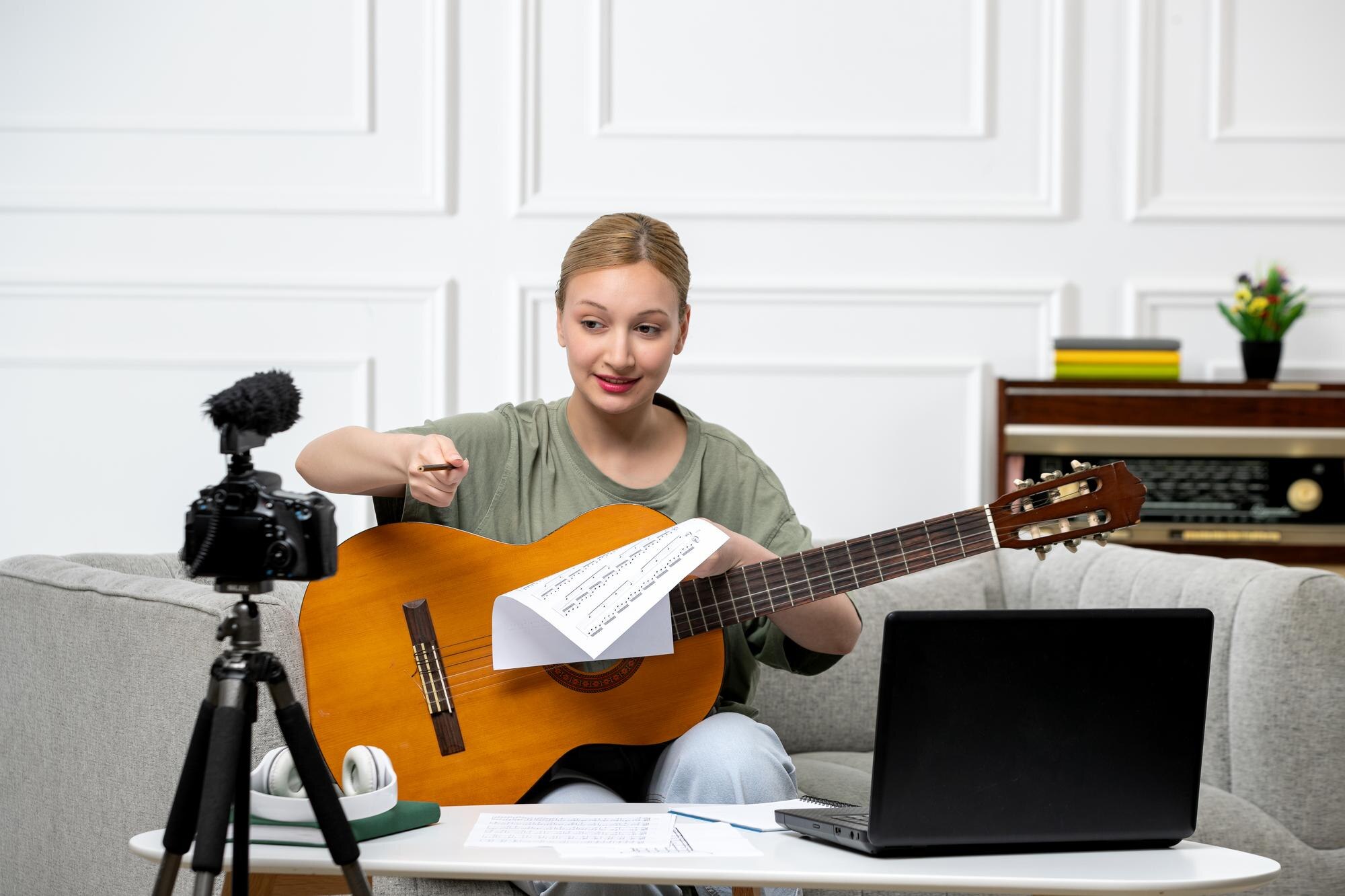 Elearning młoda śliczna piękna dziewczyna zdalnie prowadząca lekcje gry na gitarze w domu podekscytowana