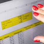 Zbliżenie kobiety z pięknymi rękami i manicurą pracującej na laptopie przewijającym się ekranem dotykowym z otwartą tablicą amortyzacji kredytu hipotecznego Finansy