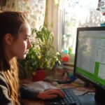 Kobieta pracująca przy komputerze z zdjęciem planu biznesowego