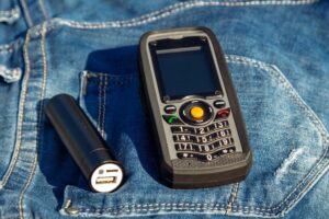 Telefon komórkowy i power bank na tle dżinsów w naturze