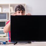 Profesjonalny inżynier naprawy naprawiający zepsuty telewizor
