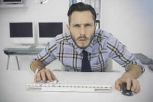 Skoncentrowany przypadkowy biznesmen pracujący przy biurku w swoim biurze