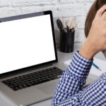 Sfrustrowany człowiek patrząc na ekran laptopa. Makieta z pustym wyświetlaczem