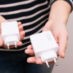 Potężne ładowarki USB do szybkiego ładowania smartfona w rękach kobiety Porównujemy rozmiary ładowarek o mocy 120 wattów i 33 wattów