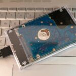 Przenośny zewnętrzny dysk twardy z przezroczystą obudową na klawiaturze laptopa