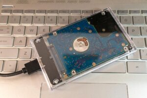 Przenośny zewnętrzny dysk twardy z przezroczystą obudową na klawiaturze laptopa