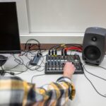 Inżynier dźwięku pracuje nad konsolą do miksowania dźwięku z podłączonymi kablami