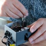 Człowiek demontażujący element elektryczny w celu naprawy