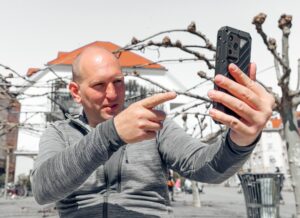 Portret przystojnego hipstera Mężczyzna w dużym mieście ze smartfonem koncepcja stylu życia