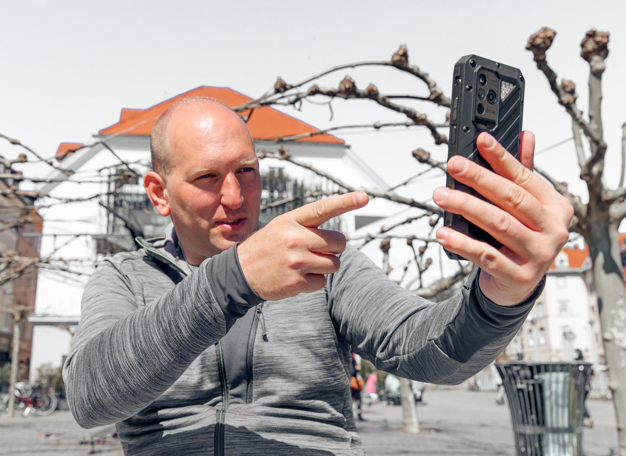 Portret przystojnego hipstera Mężczyzna w dużym mieście ze smartfonem koncepcja stylu życia