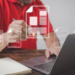 Mężczyzna korzystający z laptopa pracujący na starym drewnianym stole używa dokumentu elektronicznego ze znakiem pióra z przestrzenią do kopiowania edocument management koncepcja biura bez papieru