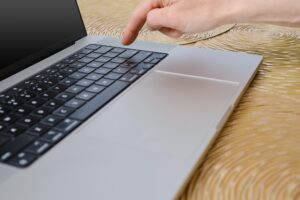 Zbliżony widok palca gotowego do naciśnięcia klawisza Enter na laptopie