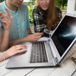 Grupa młody studencki używa laptop plenerowy