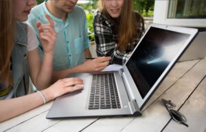 Grupa młody studencki używa laptop plenerowy