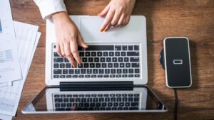 Ładowanie baterii telefonu komórkowego za pomocą urządzenia do ładowania bezprzewodowego w stole Ładowanie smartfonu na poduszce do ładowania Telefon komórkowy w pobliżu ładowarki bezprzewodowej Nowoczesna technologia stylu życia