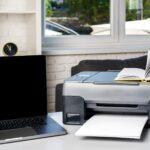 Nowa nowoczesna drukarka i laptop w biurze na stole