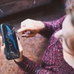 Osoba inwestująca na rynku kryptowalut giełdowych za pomocą aplikacji inwestycyjnej na smartfonie