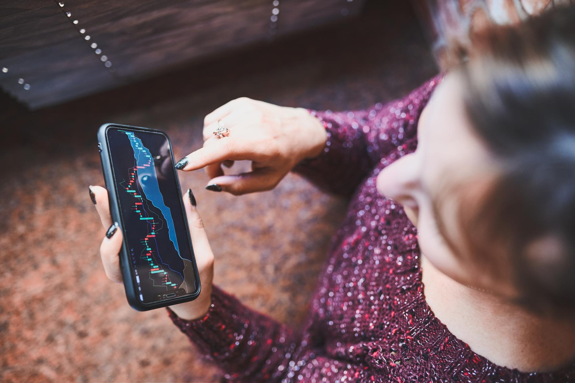 Osoba inwestująca na rynku kryptowalut giełdowych za pomocą aplikacji inwestycyjnej na smartfonie