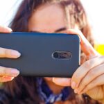 Kobieta po południu strzela przez telefon w terenie